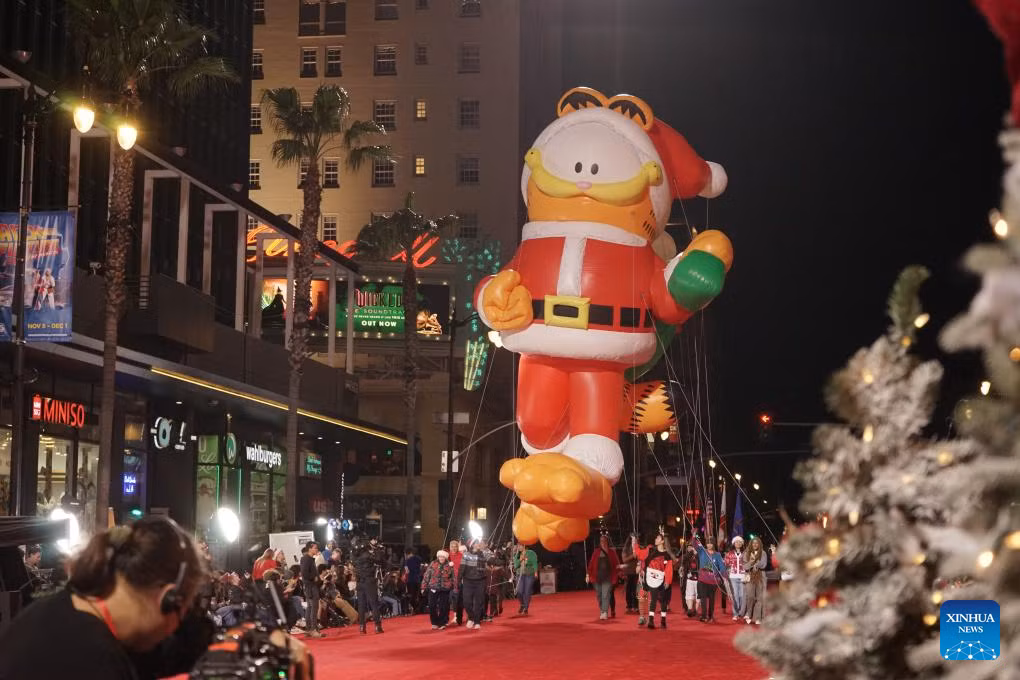 Bóng bay hình mèo Garfield trong trang phục ông già Noel tại lễ diễu hành Giáng Sinh Hollywood lần thứ 92 tổ chức ngày 1.12. Lễ hội hàng năm thu hút rất đông du khách khi có hàng trăm vũ công trình diễn ở Los Angeles, California, Mỹ. Ảnh: Zeng Hui/Xinhua