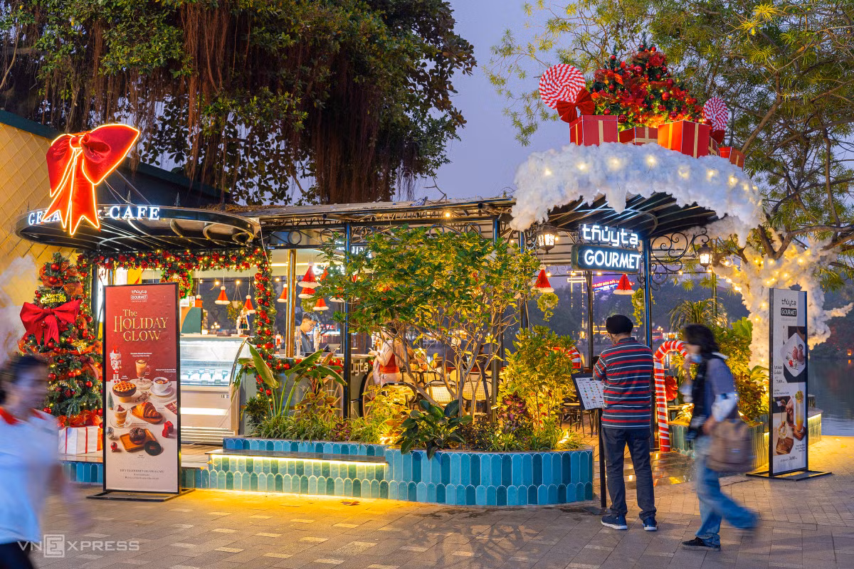 Cửa hàng cà phê, bánh ngọt trên đường Lê Thái Tổ, quận Hoàn Kiếm, trang trí với nhiều nơ đỏ, cây thông, chuông thánh đường và vòng nguyệt quế.