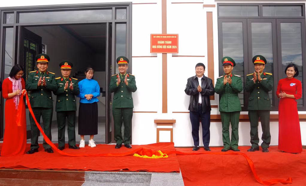 Các đại biểu kéo băng khánh thành nhà đồng đội.