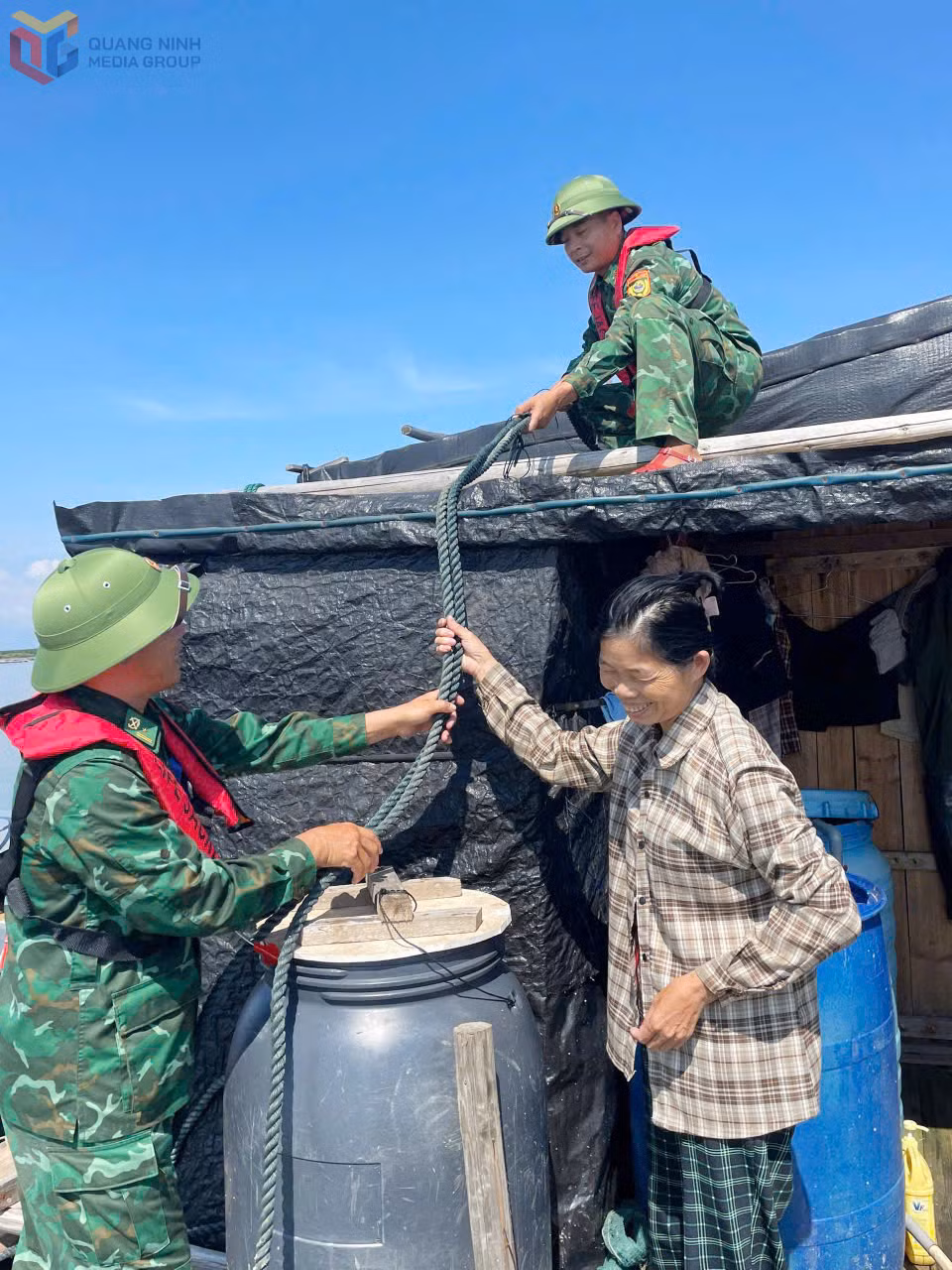 Lực lượng BĐBP hỗ trợ ngư dân chằng buộc, gia cố bè nuôi trồng thủy sản. 