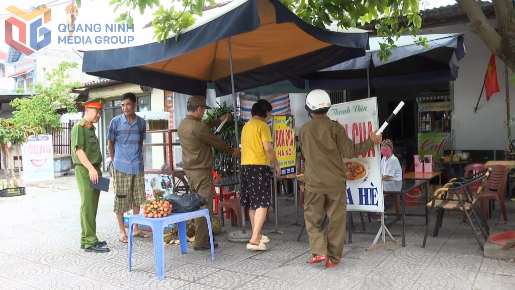 Lực lượng Công an xã và An ninh cơ sở phường Bình Khê nhắc nhở và giúp người dân dọn dẹp các vật dụng, biển quảng cáo lấn chiếm vỉa hè.