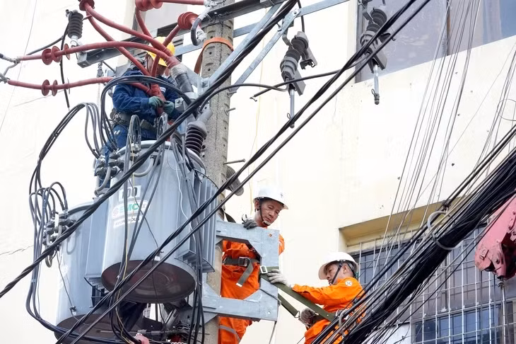 Nhân viên Công ty Điện lực Phú Thọ, TP.HCM bảo trì lưới điện trung thế đảm bảo nguồn điện sinh hoạt cho người dân - Ảnh: HỮU HẠNH