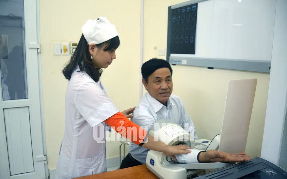 Nhân viên y tế Trung tâm Y tế TX Quảng Yên đo huyết áp cho người bệnh (12-2017). Ảnh: Nguyễn Hoa