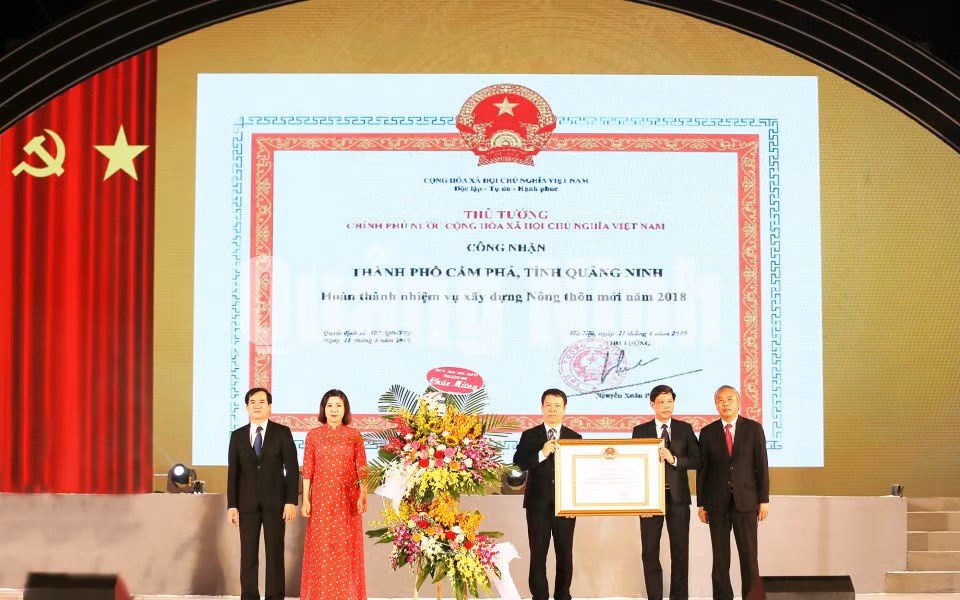 Thừa ủy quyền của Thủ tướng Chính phủ, đồng chí Phùng Đức Tiến, Thứ trưởng Bộ NN và PTNT đã trao Bằng công nhận thành phố hoàn thành nhiệm vụ xây dựng nông thôn mới cho TP. Cầm Phả (6-2019). Ảnh: Đỗ Phương