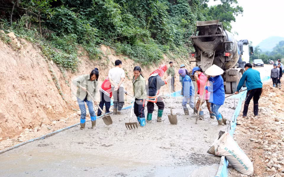 Người dân thôn Là Phen, xã Yên Than, huyện Tiên Yên hiến đất, góp công làm đường bê tông vào thôn (11-2015). Ảnh: Đỗ Phương