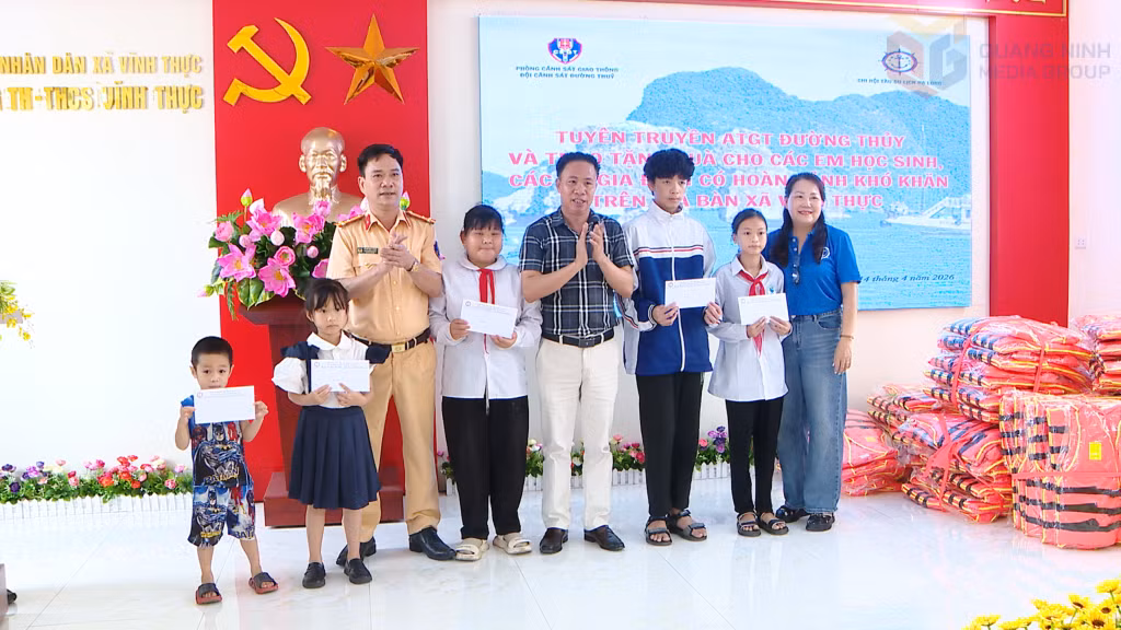 Đại diện Phòng CSGT (Công an tỉnh) và Chi hội tàu Du lịch Hạ Long tặng quà các cháu học sinh vượt khó trên địa bàn xã Vĩnh Thực.