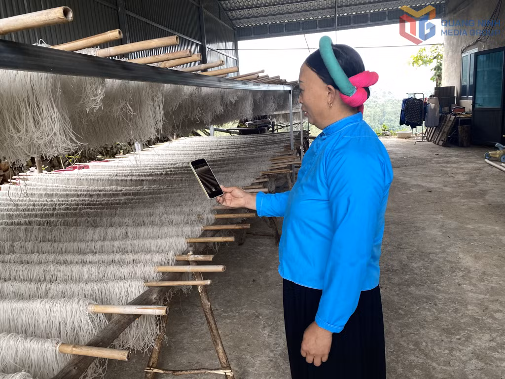 Chị Ninh Mắc Nui (thôn Khe Lục, xã Đông Ngũ) sử dụng điện thoại để quảng bá sản phẩm miến dong của gia đình.