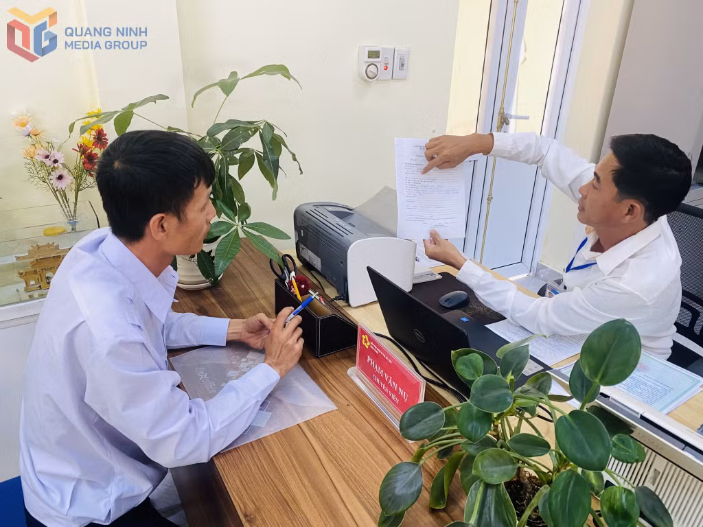 Cán bộ của điểm tiếp nhận TTHC Ngọc Vừng (đặc Khu Vân Đồn) hướng dẫn người dân nộp TTHC.