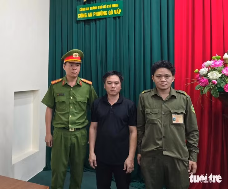 Nguyễn Hữu Tuấn (áo đen) tại cơ quan công an - Ảnh: MINH HÒA
