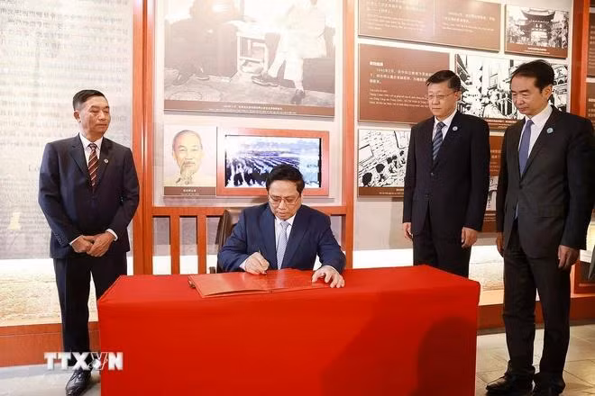 Thủ tướng Phạm Minh Chính viết lưu bút khi đến thăm Khu di tích nơi ở của Chủ tịch Hồ Chí Minh tại thành phố Côn Minh. (Ảnh: Dương Giang/TTXVN)
