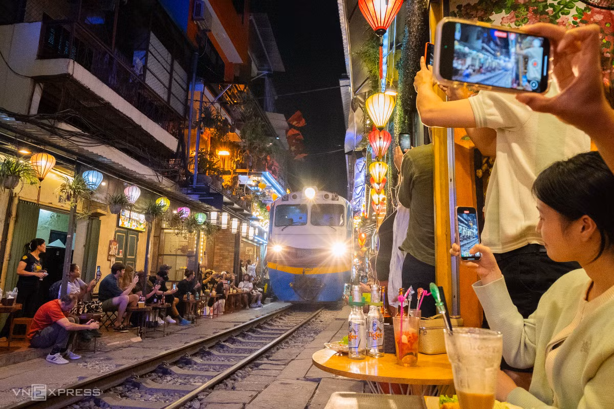 Tàu xuất hiện là lúc du khách mong chờ nhất, nhiều người đưa điện thoại, máy quay hướng ra đường ray để có bức hình ưng ý. Không gian tầng thấp được khách chọn nhiều hơn tầng trên, dù chen chúc.
