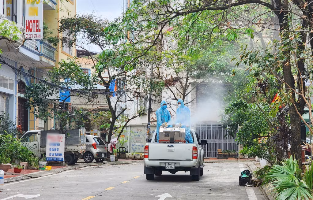 Nhân viên y tế của Trung tâm Kiểm soát Bệnh tật Quảng Ninh thực hiện phun hóa chất diện rộng để diệt muỗi phòng chống bệnh sốt xuất huyết tại phường Bãi Cháy, TP Hạ Long.