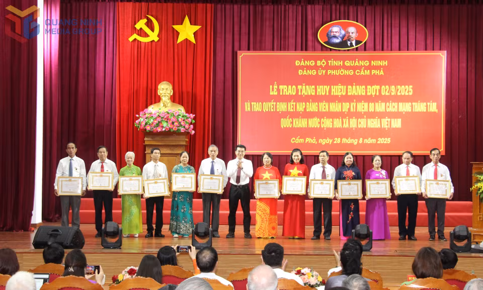 Đồng chí Hoàng Việt Dũng, Phó Bí thư Đảng ủy, Chủ tịch UBND phường Cẩm Phả, trao Huy hiệu Đảng cho các đồng chí 40 năm tuổi Đảng.