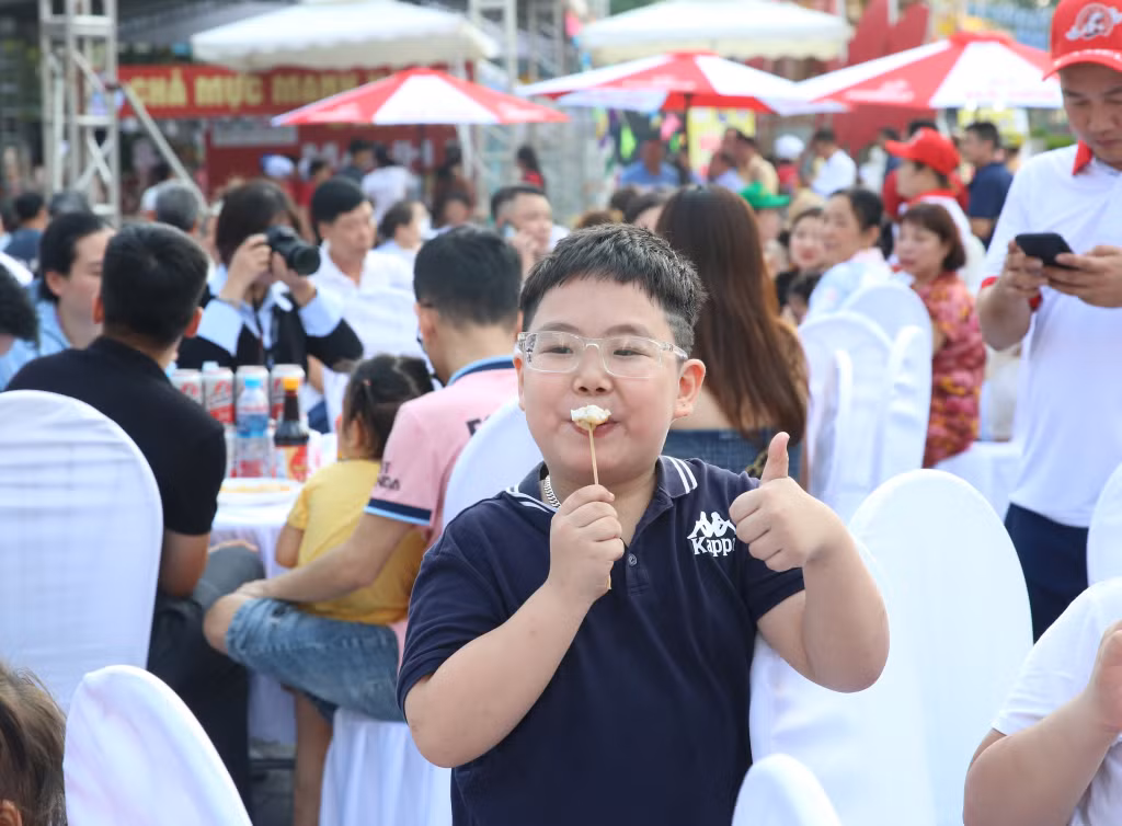 Những thực khách nhỏ tuổi hân hoan thưởng thức chả mực.
