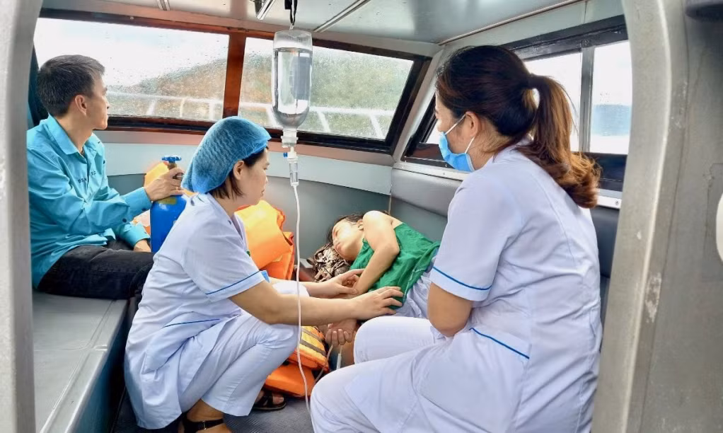 Nhân viên y tế chăm sóc cho sản phụ trên xuồng cấp cứu.