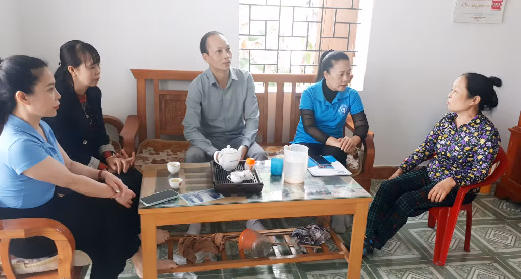 Cán bộ BHXH tỉnh và BHXH huyện Đầm Hà phổ biến cơ chế, chính sách về BHYT cho người dân.