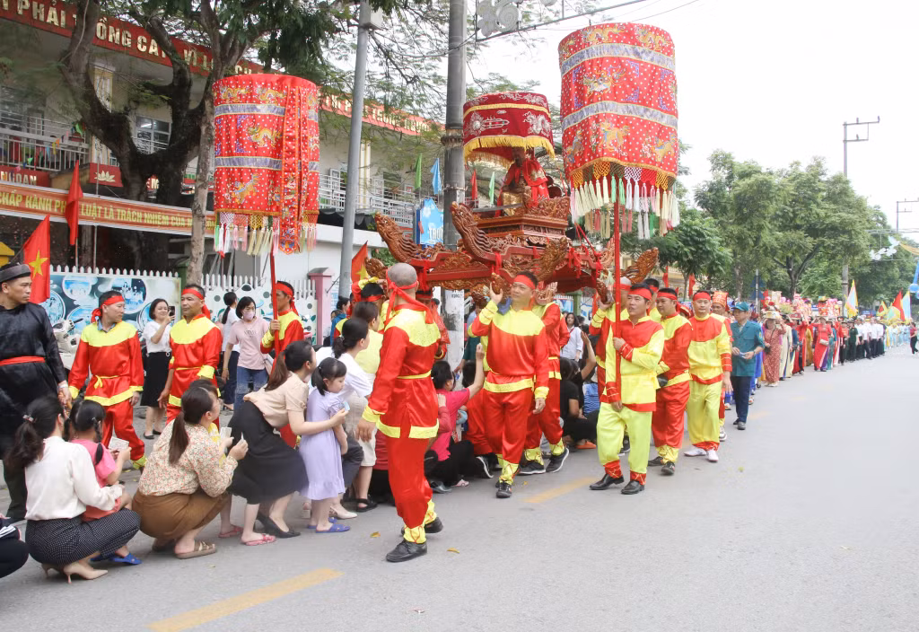 Người dân háo hức xếp hàng chui kiệu khi đoàn rước tượng Đức thánh Trần đi qua, với mong muốn cầu chúc bình an, may mắn, tạo nét văn hóa lễ hội độc đáo.