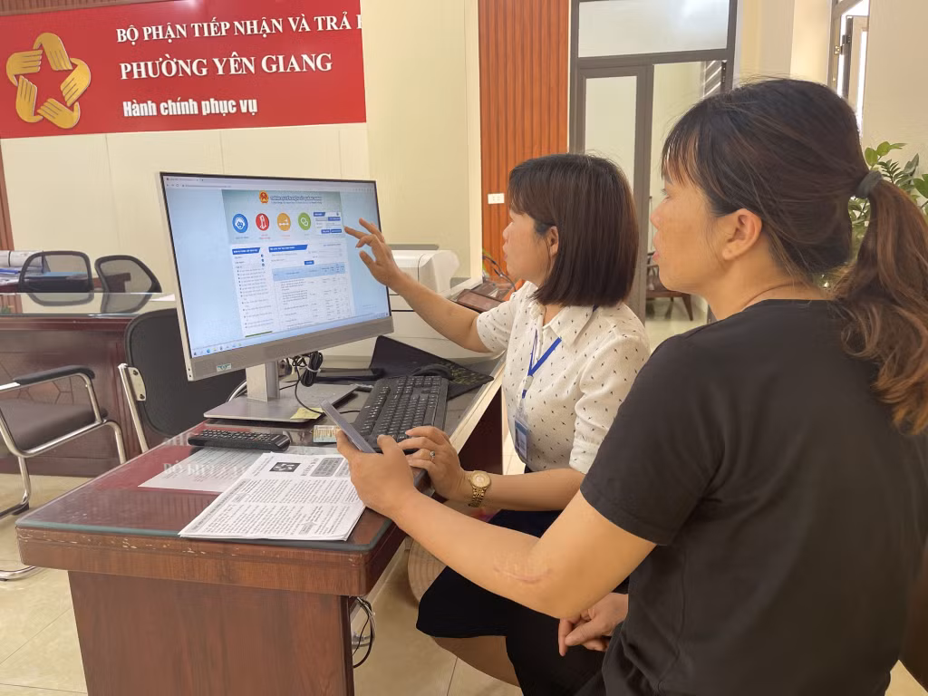 Cán bộ phường Yên Giang hướng dẫn người dân sử dụng cổng dịch vụ công trực tuyến.