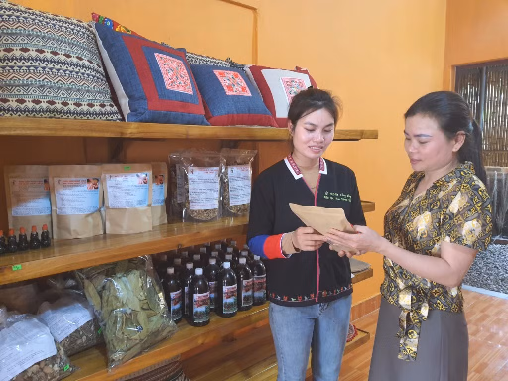 Nhân viên nhà hàng dân tộc Dao Thanh Y Yên Tử giới thiệu sản phẩm thảo dược dân tộc cho du khách.