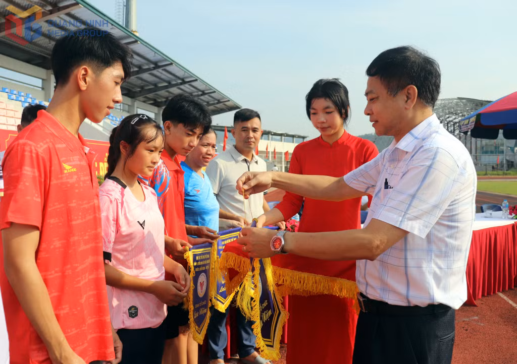Đại diện Ban Tổ chức trao cờ chào mừng các đoàn về tranh tài.