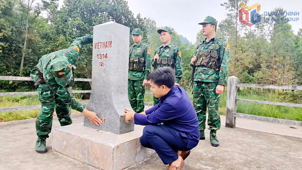  Cán bộ, chiến sĩ Đồn Biên phòng Cửa khẩu Hoành Mô phối hợp với người dân thôn Cửa Khẩu, xã Hoành Mô kiểm tra cột mốc biên giới.