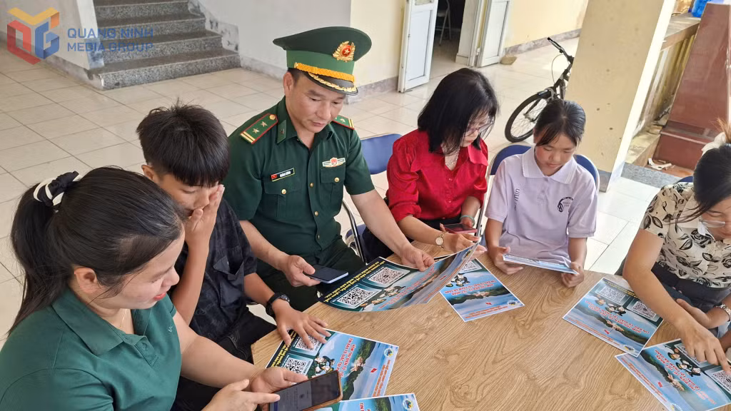 Cán bộ Đồn Biên phòng Đảo Trần hướng dẫn giáo viên, học sinh điểm trường thôn Trần cách sử dụng mã QR.