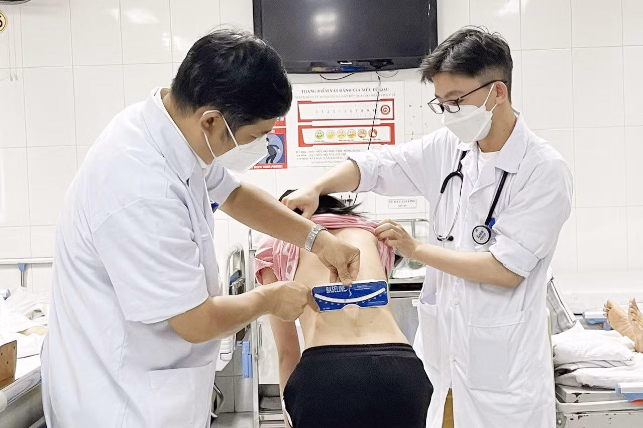 Các bác sĩ Bệnh viện Hữu nghị Việt - Đức kiểm tra cột sống cho một nữ sinh sau phẫu thuật. Ảnh: Xuân Lộc.