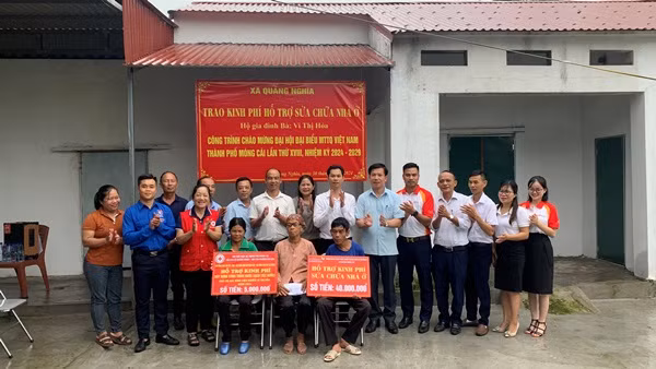 Các đơn vị trao tặng kinh phí sửa chữa nhà ở cho bà Vi Thị Hỏa, thôn 1, xã Quảng Nghĩa, tháng 5/2024.