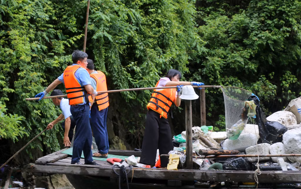 Đại diện lãnh đạo Ban Tuyên giáo Tỉnh ủy thu gom phao xốp, rác thải nhựa trôi nổi trên vịnh.