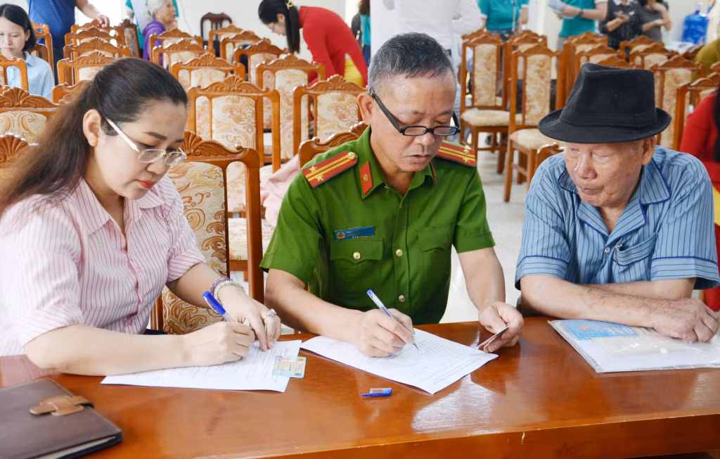 Cán bộ BHXH tỉnh và Công an phường Việt Hưng ghi phiếu khảo sát ý kiến người hưởng lương hưu, trợ cấp BHXH cho cán bộ hưu trí phường Việt Hưng (TP Hạ Long).