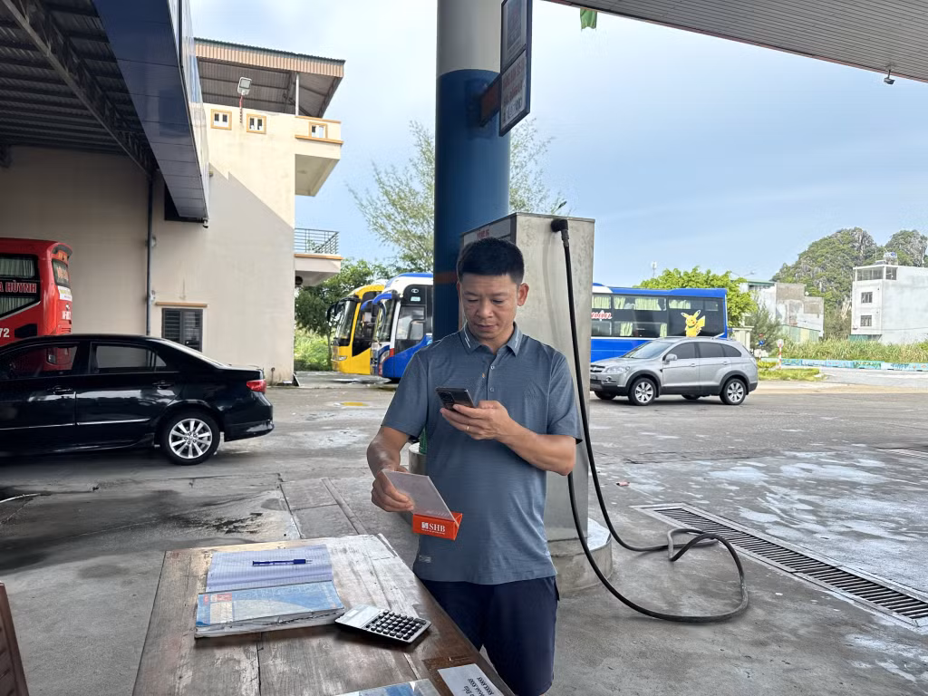 Người dân thanh toán bằng cách quét mã QR code tại cửa hàng xăng dầu trên địa bàn huyện Vân Đồn.