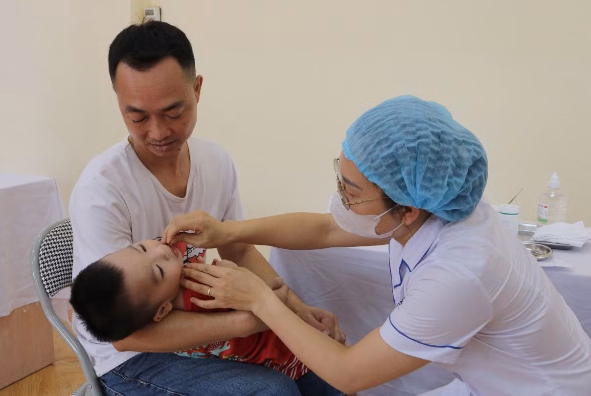 Cho trẻ uống vitamin A trong chiến dịch “Ngày Vi chất dinh dưỡng” năm 2024 tại điểm uống Nhà văn hóa Đại Áng (huyện Thanh Trì, Hà Nội).