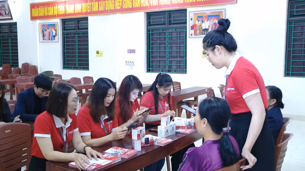 Nhân viên Viettel Quảng Ninh hỗ trợ người dân thôn Thanh Bình, xã Việt Dân (TX Đông Triều) chuyển đổi sim 2G sang 4G.