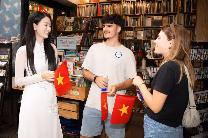 Du khách quốc tế hào hứng vì được tặng lá cờ đỏ sao vàng khi trải nghiệm điểm đến Thành phố Hồ Chí Minh. (Ảnh: CTV/Vietnam+)