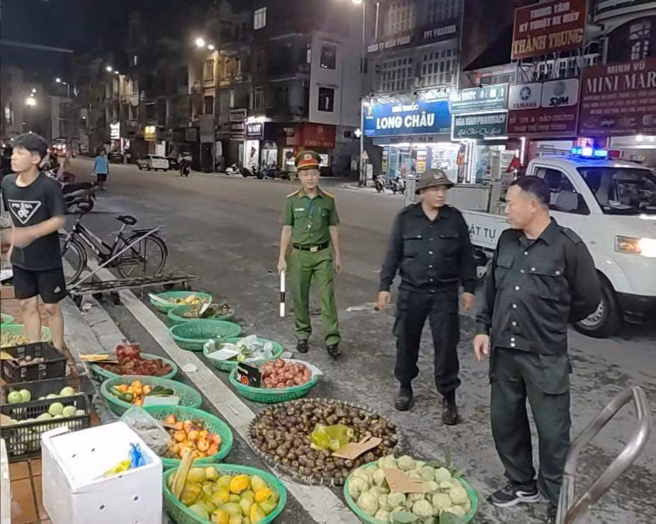 Công an phường Hồng Gai tuyên truyền, nhắc nhở hàng quán lấn chiếm vỉa hè khu vực chợ Hạ Long II. Ảnh: Công an tỉnh
