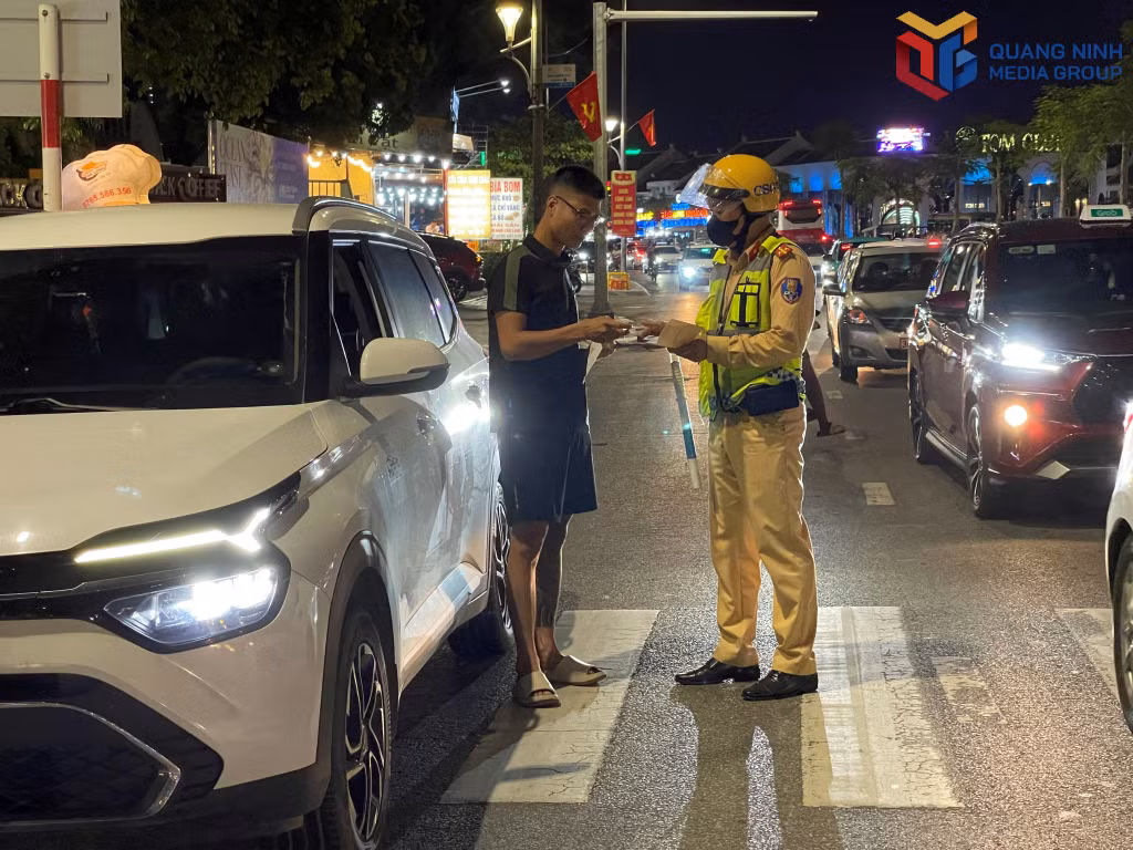 Cán bộ đội CSGT đường bộ số 2, Phòng CSGT (Công an tỉnh) nhắc nhở du khách ngoại tỉnh phải dừng, đỗ xe đúng nơi quy định.