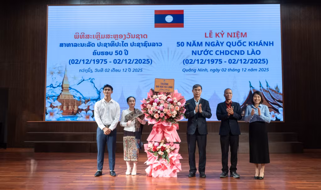 Đảng ủy, Ban Giám hiệu, Hội đồng Trường tặng hoa chúc mừng lưu học sinh Lào nhân Kỷ niệm 50 năm Ngày Quốc khánh nước Cộng hòa Dân chủ Nhân dân Lào.