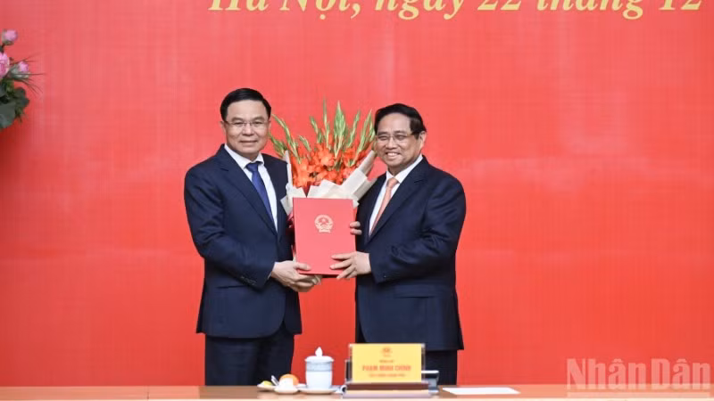 Bí thư Đảng ủy Chính phủ, Thủ tướng Chính phủ Phạm Minh Chính trao Quyết định bổ nhiệm, tặng hoa chúc mừng đồng chí Lê Mạnh Hùng, Quyền Bộ trưởng Công thương. (Ảnh: TRẦN HẢI)