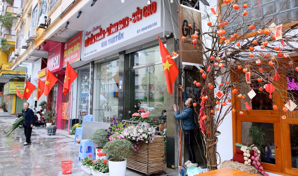 Người dân vừa tất tả dọn dẹp nhà cửa, vừa tranh thủ treo cờ, cắm hoa chuẩn bị đón Tết ấm, Xuân vui.