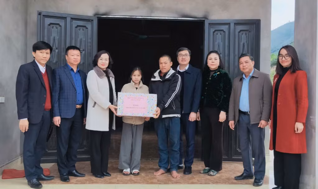 Đồng chí Trưởng Ban Tổ chức Tỉnh ủy trao tặng quà Tết cho cháu Lý Minh Huyền, thôn Cái Gian, xã Nam Sơn.