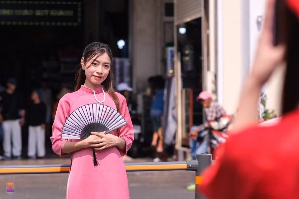 Bạn trẻ chụp ảnh với áo dài trước cửa chợ Bến Thành (TP.HCM) ngày 1/1. Ảnh: Linh Huỳnh.