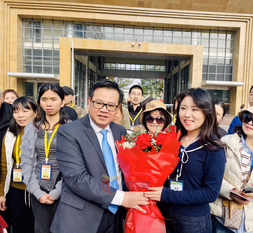 Đồng chí Hoàng Bá Nam, Tỉnh ủy viên, Bí thư Thành ủy Móng Cái tặng hoa chào đón đoàn khách đầu tiên.