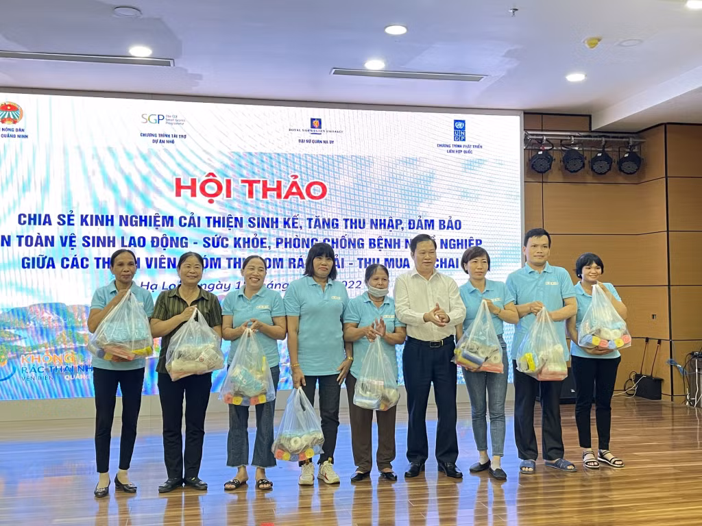 Đại diện Ban điều hành dự án xây dựng mô hình cộng đồng quản lý, thu gom và xử lý rác thải nhựa vùng ven Vịnh Hạ Long tặng quà cho các thành viên nhóm thu gom rác thải - thu mua ve chai.