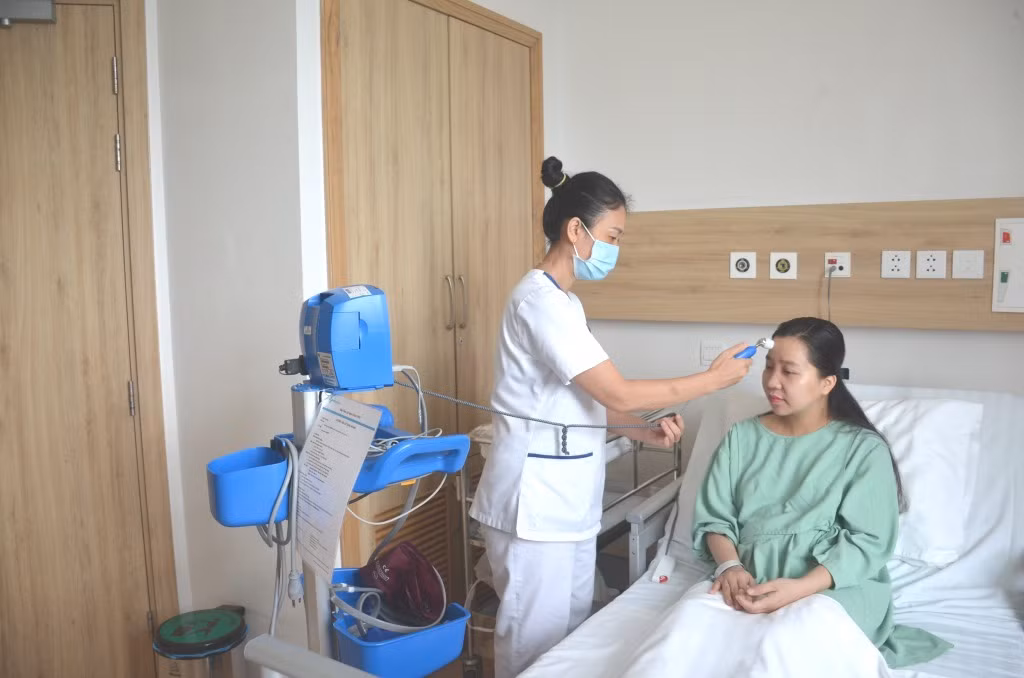 Sản phụ sau mổ đẻ được nhân viên Vinmec Hạ Long khám, theo dõi sức khỏe hằng ngày.