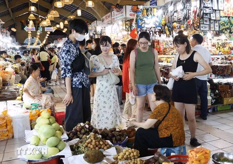 Du khách Hàn Quốc tìm hiểu đặc sản trái cây Nam Bộ trong chợ Bến Thành, Quận 1, Thành phố Hồ Chí Minh. (Ảnh: Hồng Đạt/TTXVN)
