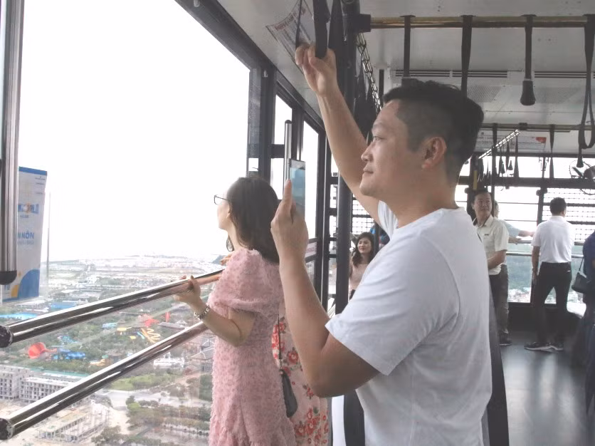 Du khách ngắm vẻ đẹp vịnh Hạ Long từ cáp treo nữ hoàng tại tổ hợp vui chơi giải trí Sun World Halong Complex.