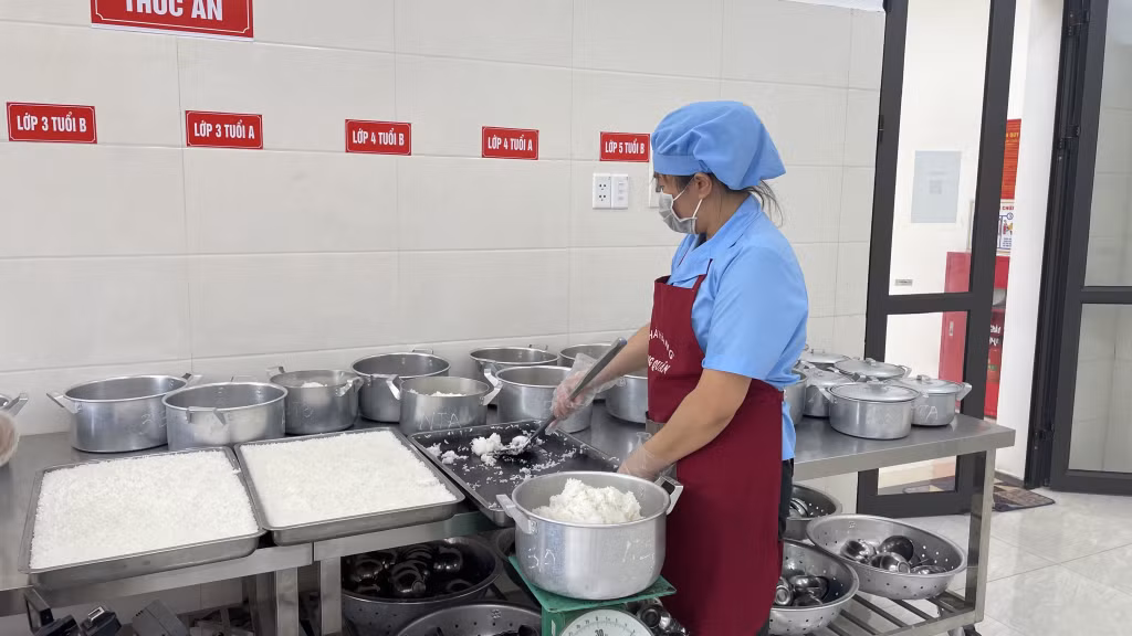 Nhân viên nấu ăn của Trường Mầm non Yên Giang (TX Quảng Yên) chia cơm cho trẻ.