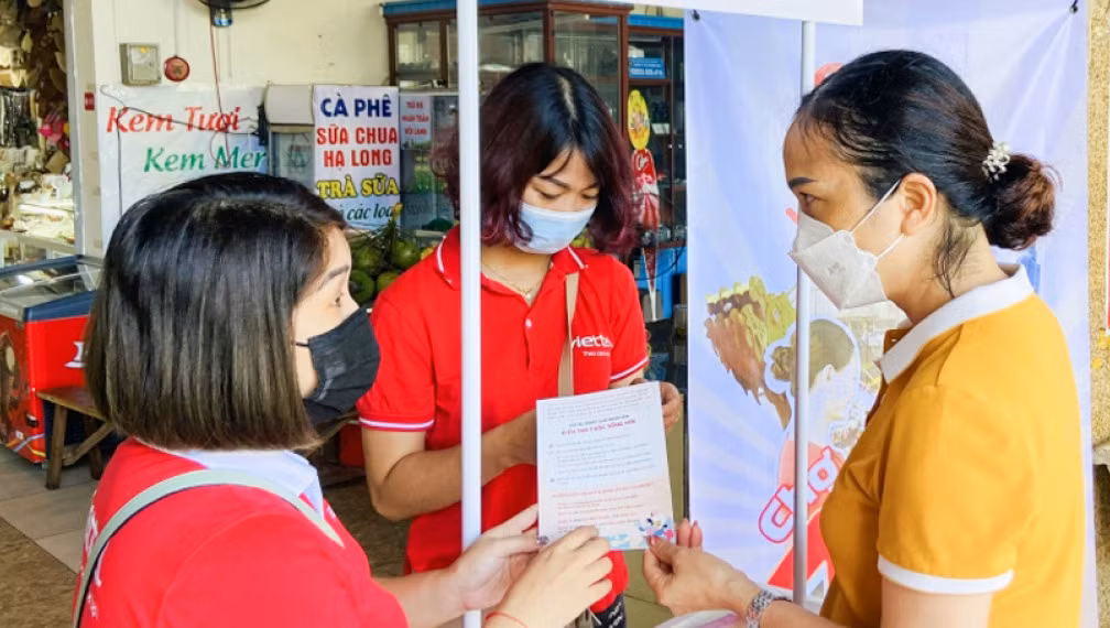 Nhân viên Viettel Quảng Ninh hướng dẫn tiểu thương Chợ Hạ Long 1 (TP Hạ Long) sử dụng ứng dụng Viettel Money để thanh toán trực tuyến.