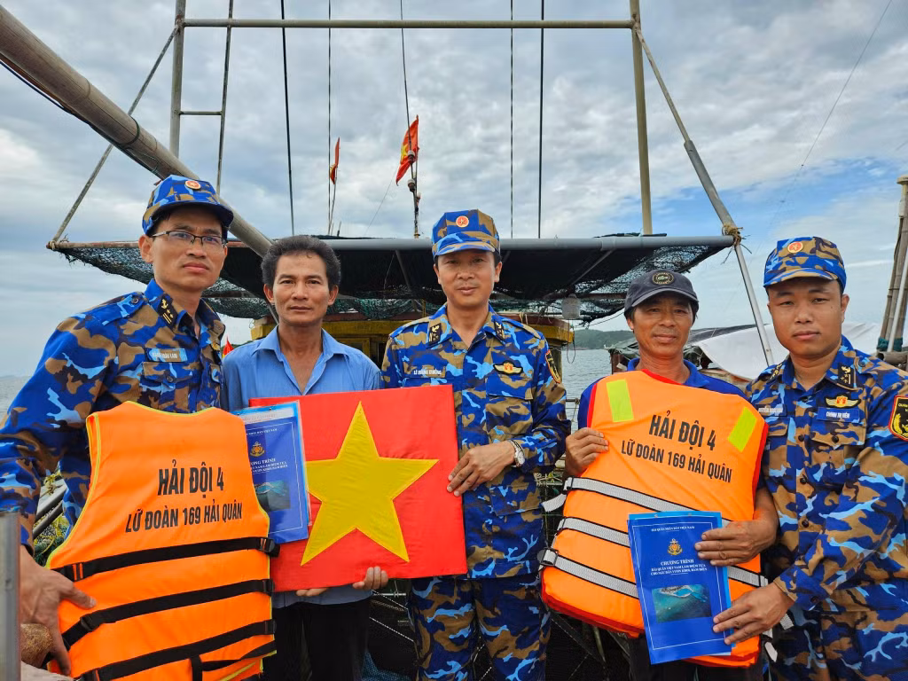 Thượng tá Lê Quang Trưởng, Phó Lữ đoàn trưởng cùng đoàn công tác trao tờ rơi và quà cho ngư dân.