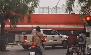 Xe bán tải mắc kẹt khi cố vượt gác chắn đường tàu ở Hà Nội